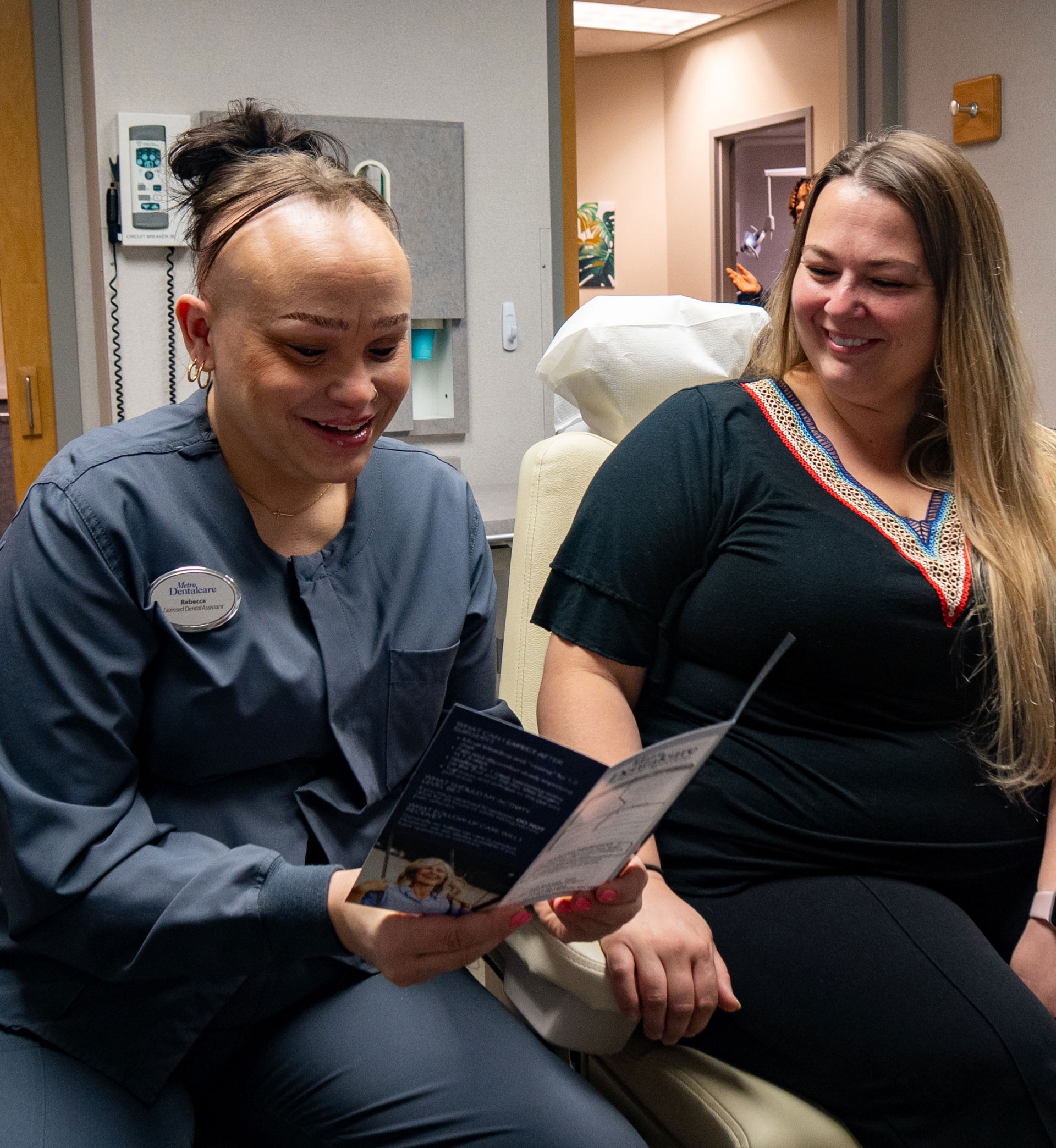 dental assistant going over information with patient in exam room